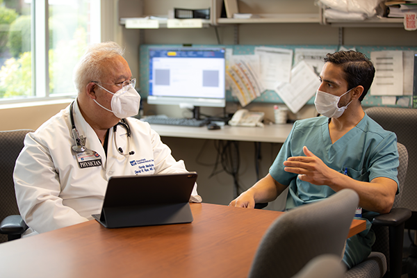 Dr. Ruiz speaks with a resident in training in an office setting