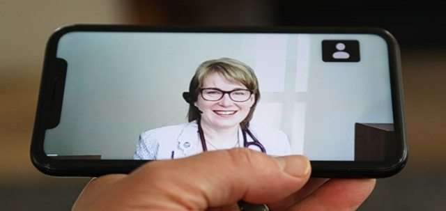 A patient speaks to a provider through video on a mobile device