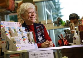 A smiling volunteer greets visitors from the Ketchikan Medical Center gift shop counter