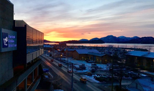 A view of the sunset and water reflecting off of the PeaceHealth Ketchikan Medical Center