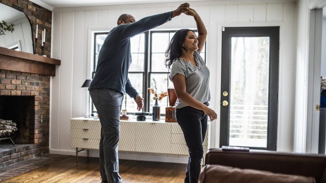 Man and woman dance in a living room