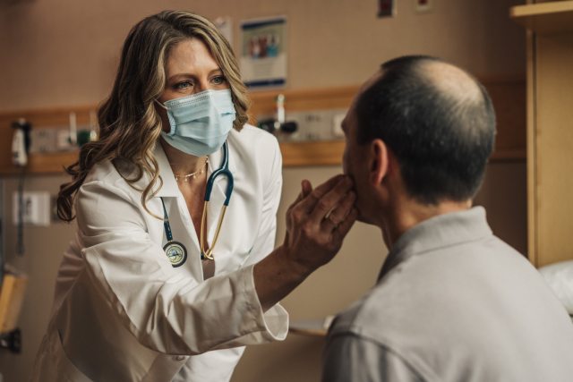 A PeaceHealth Care Provider closely examines a patient's face in a relaxed clinical setting