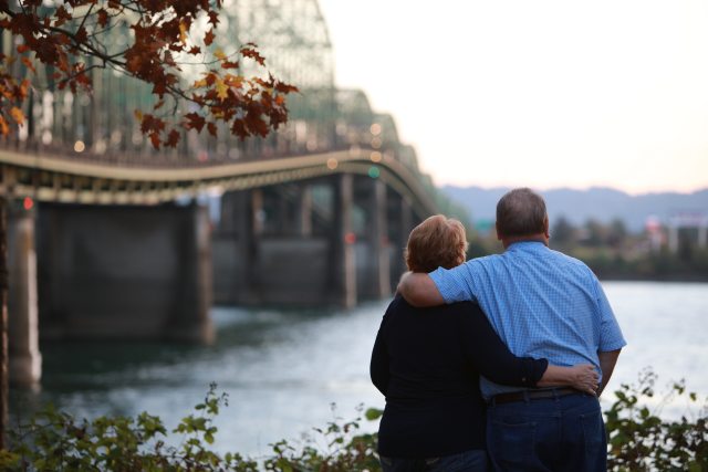 A couple embraces while looking out at the Columbia River.