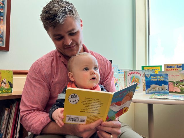 Father reads to his infant son