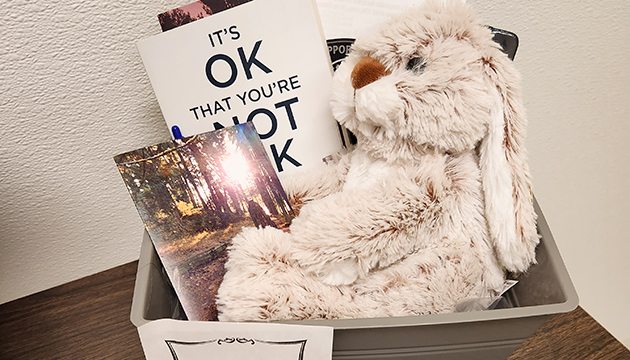 Comforting items and resources in basket for people in grief