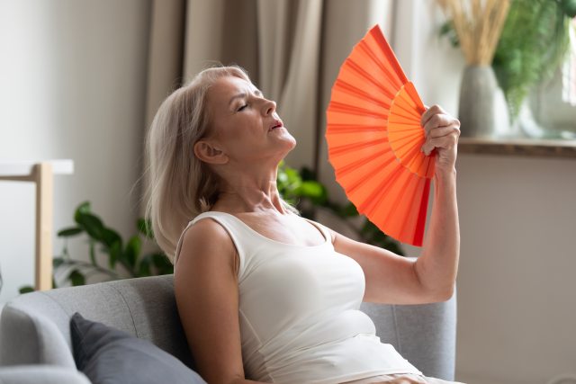 Woman fanning herself to cool down.