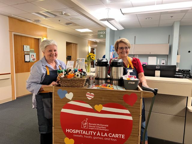 Two Ronald McDonald House Charities volunteers with the new hospitality cart at PeaceHealth Sacred Heart Medical Center at RiverBend