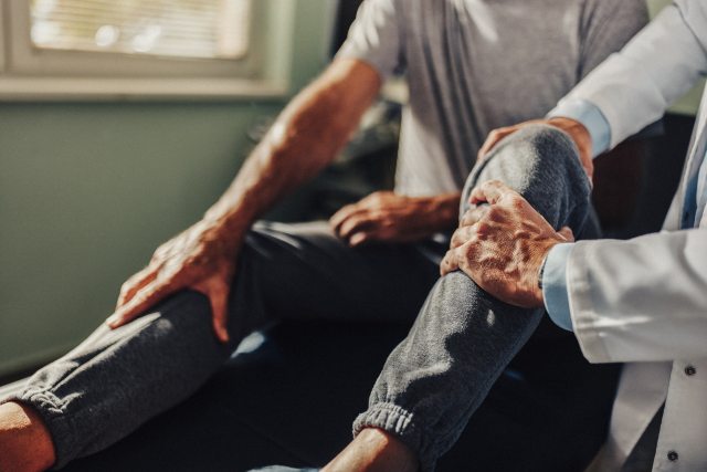 A healthcare provider examines a patient's knee