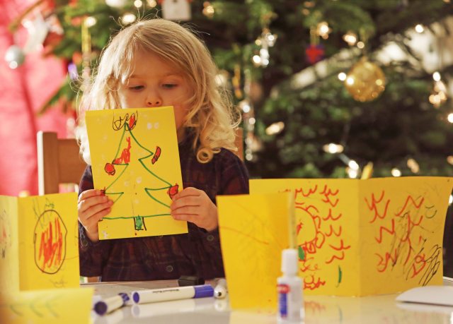 Little girl making holiday greeting cards.