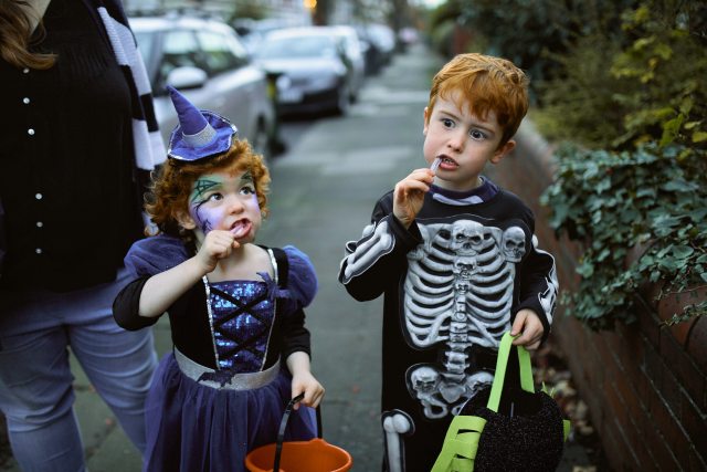 Young kids enjoying candy on Halloween.