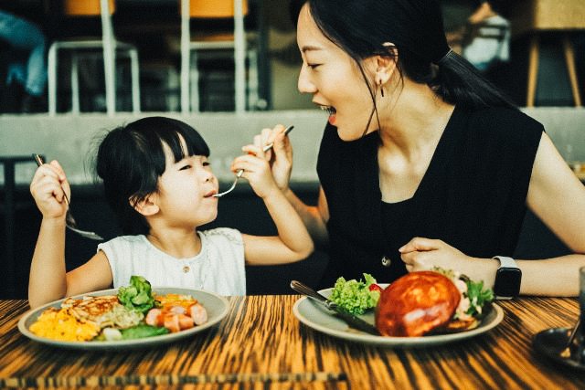 A woman and child eating food.