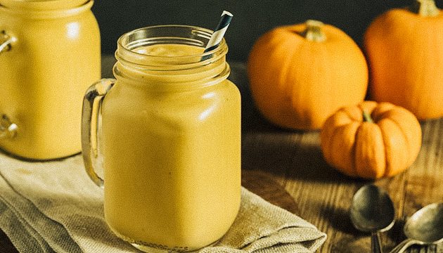 pumpkin smoothie in a glass with a paper straw