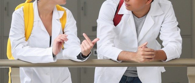 Two medical residents talking in a medical center stairwell