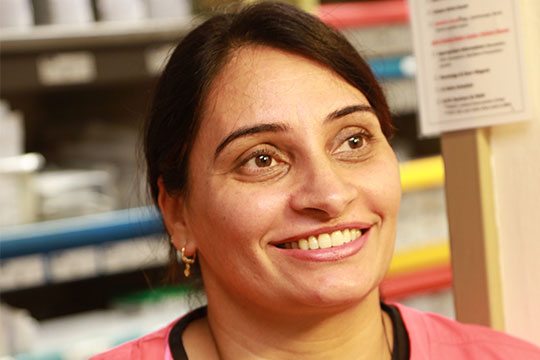A pharmacist smiles while looking off camera