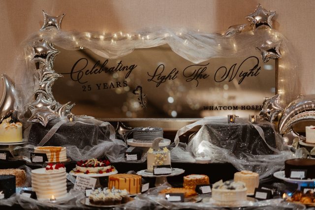 A sign that reads "Light the night" surrounded by candles and table decorations