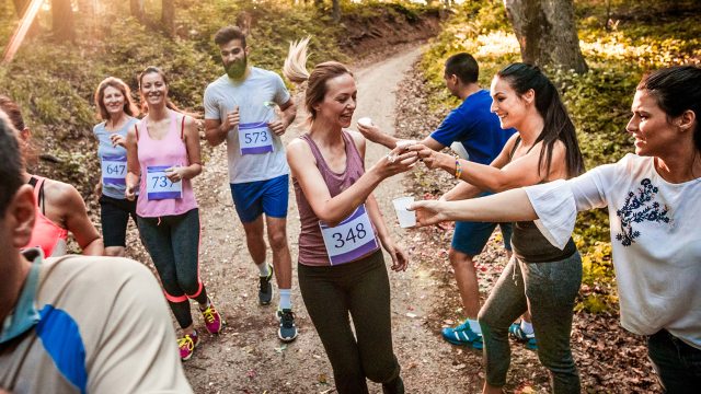 Volunteers hand out water to passing runners