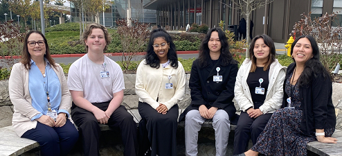 A group of mentor kids sitting outside peacehealth southwest and smiling at the camera