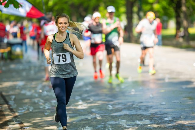 woman wearing race bib jogs along the course outside