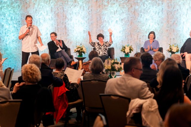 Four people on stage cheering during the healthcare reimagined celebration
