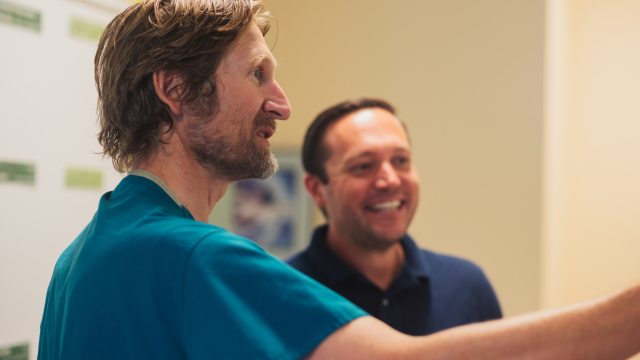 Two caregivers smile and have a discussion