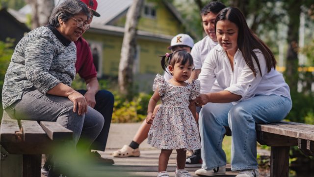 A multigenerational family enjoys time together in a park-like setting