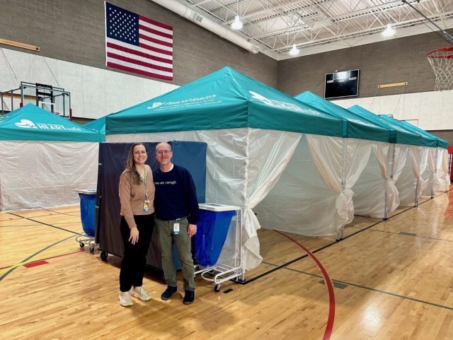 Clinical leadership from Oregon Cardiology and the Oregon Heart and Vascular Institute pose for a photo in the high school gymnasium next to donor screening tents