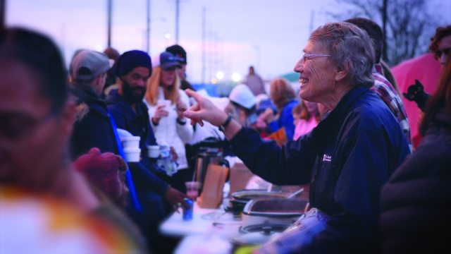 A caregiver smiling while volunteering at an event