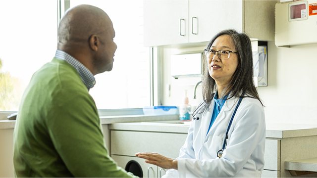 A caregiver speaks with a clinician in a clinical setting