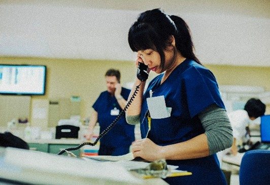 Caregiver speaks on the phone in a clinical setting