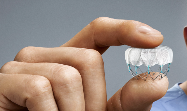 A person holds the WATCHMAN device, which fits easily between their thumb and forefinger and looks like a small parachute