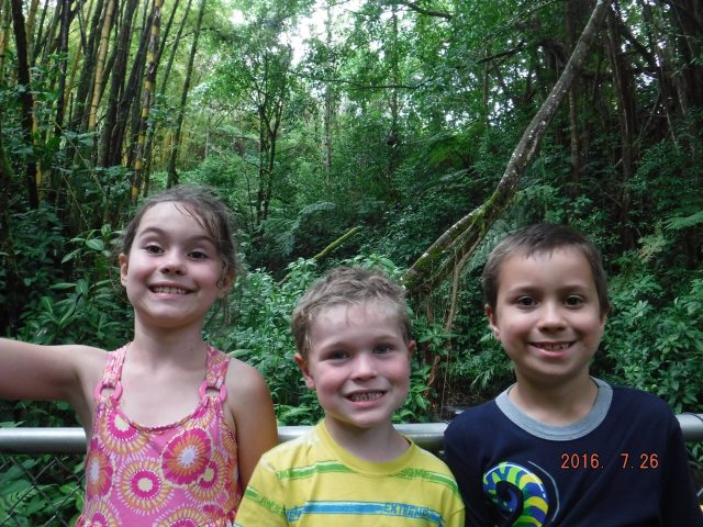 Three kids outdoors smiling for the camera