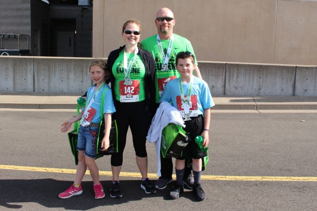 The Ellie family poses for a photo in their bibs after a marathon