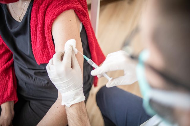 A provider administers a vaccine in the arm of a patient