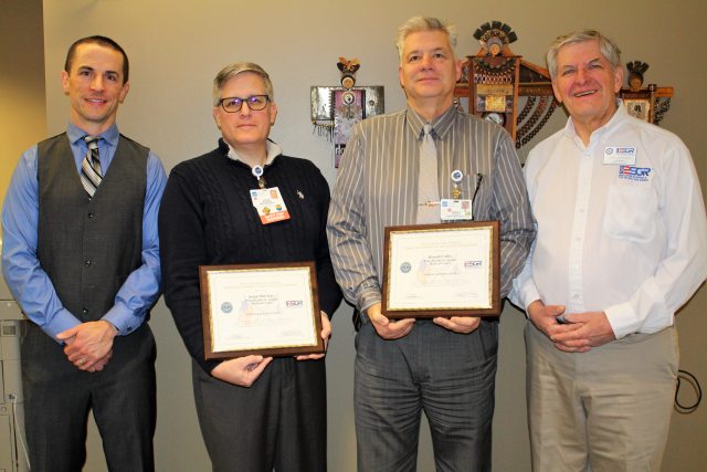 A group of caregivers hold certificate awards