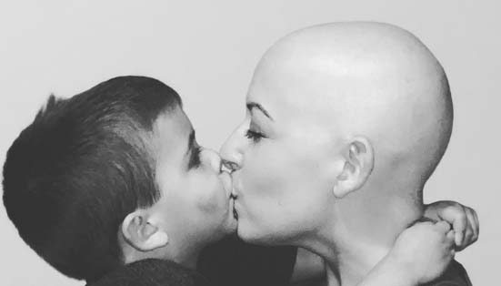 Black and white photo of Chelsea Nelson and son kissing