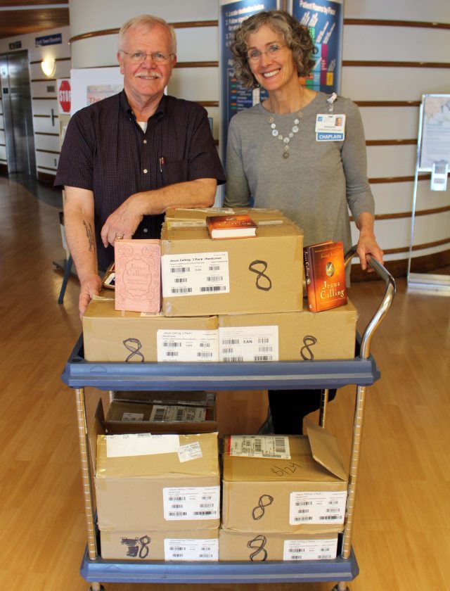 A couple displaying books on boxes