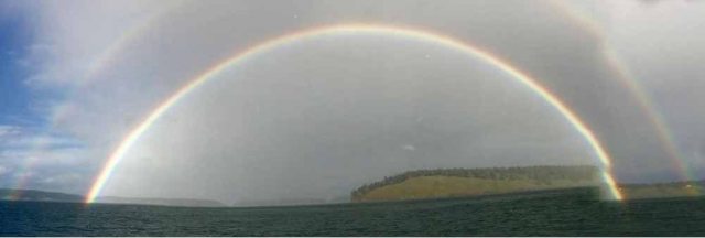A double rainbow against a cloudy gray sky
