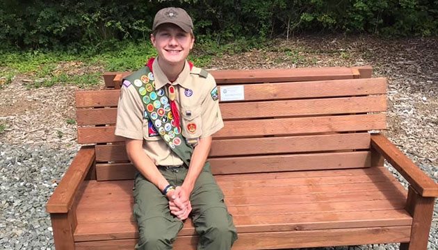 Eagle Scout sitting on a bench outside