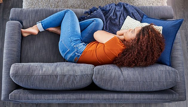young woman lying on couch