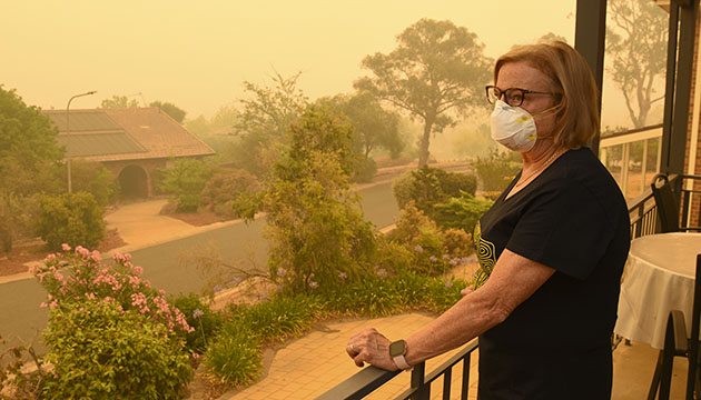 woman wears a mask outside on a smokey day