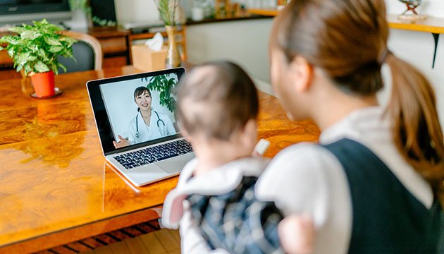 young mother with baby talk with a doctor via laptop