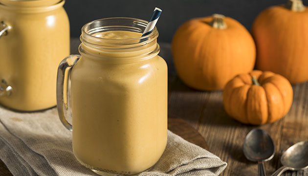 pumpkin smoothie in a glass with a paper straw