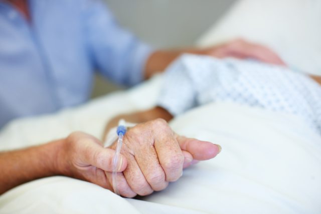 Health care provider or family member holding a patient's hand