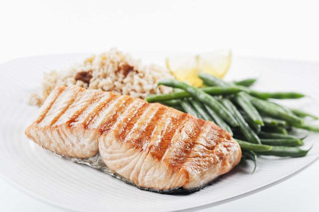 Fillet of fish, green beans and wild rice on a white plate