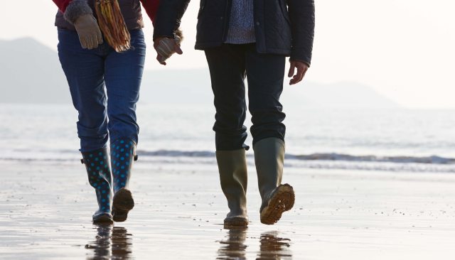 A couple walking on the beach holding hands