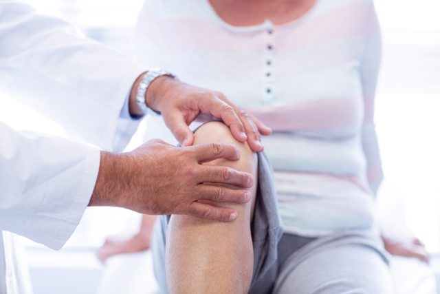 A provider examines a patient's knees