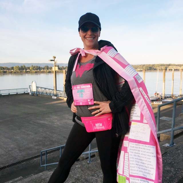 Jaime Wyatt Miller wears a pink breast cancer cape and smiles on the Vancouver waterfront